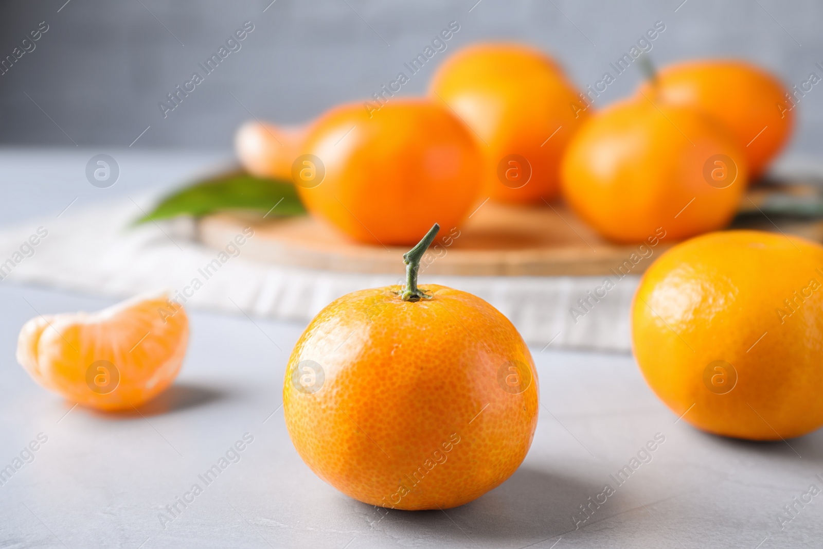 Photo of Fresh ripe tangerine on light table, closeup