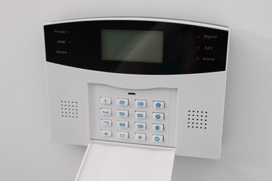 Photo of Home security alarm system on white wall indoors