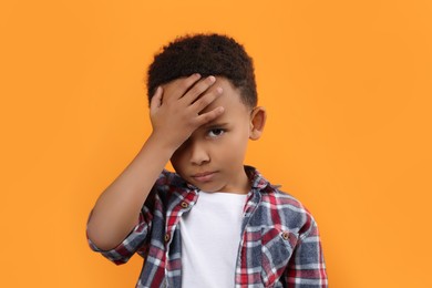 Photo of Portrait of emotional African-American boy on orange background