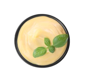 Photo of Tasty cheese sauce with basil in bowl isolated on white, top view