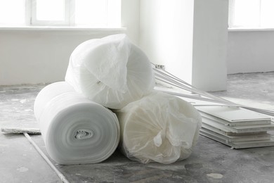 Photo of Polyethylene foam rolls on floor near windows in room