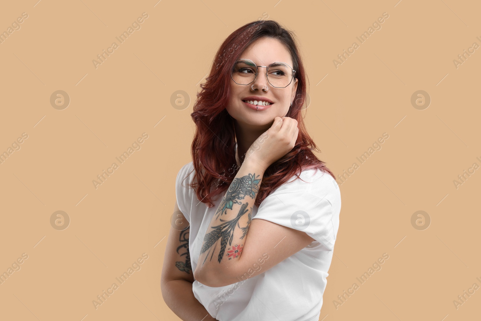 Photo of Portrait of beautiful tattooed woman on beige background