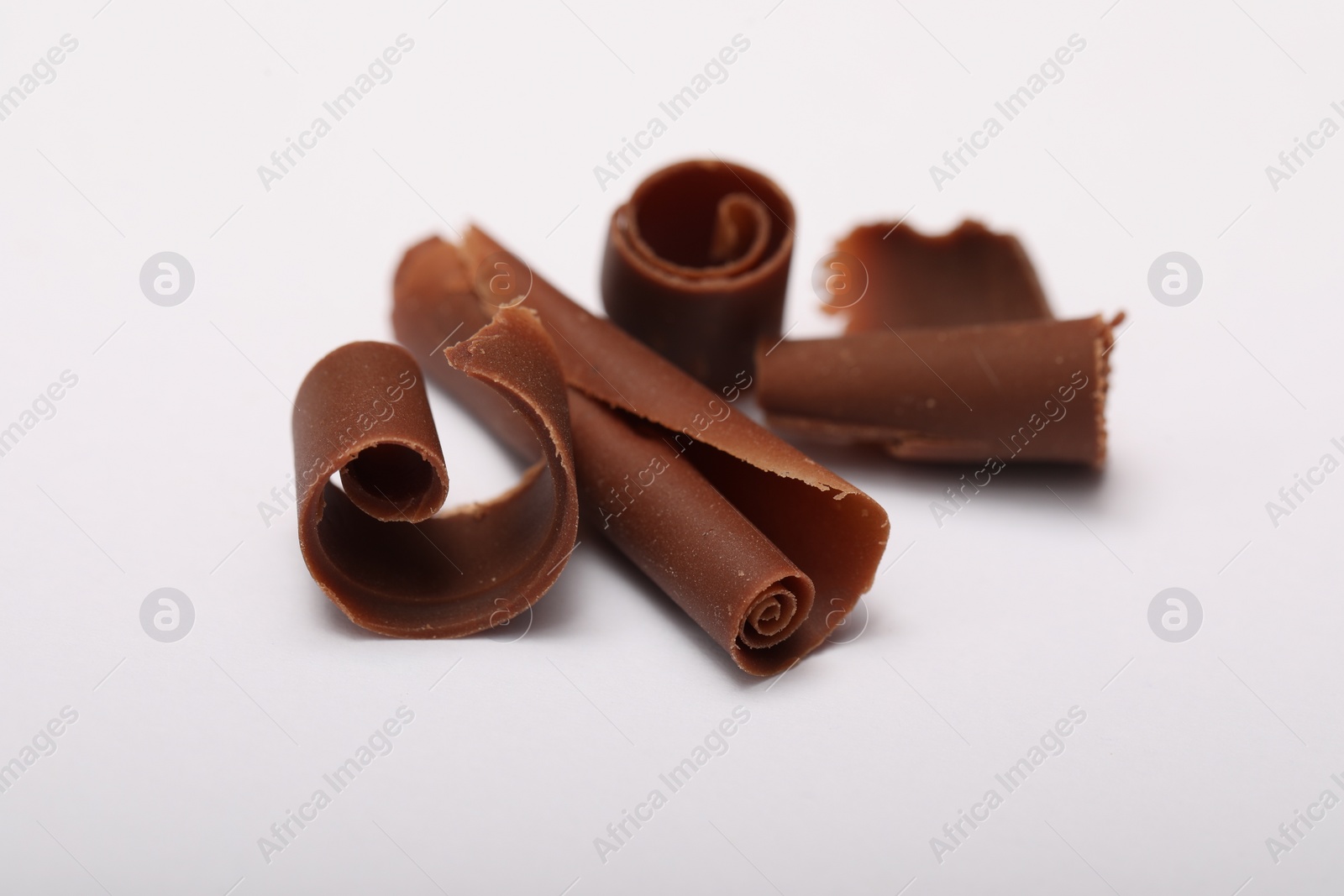 Photo of Many tasty chocolate shavings on white background