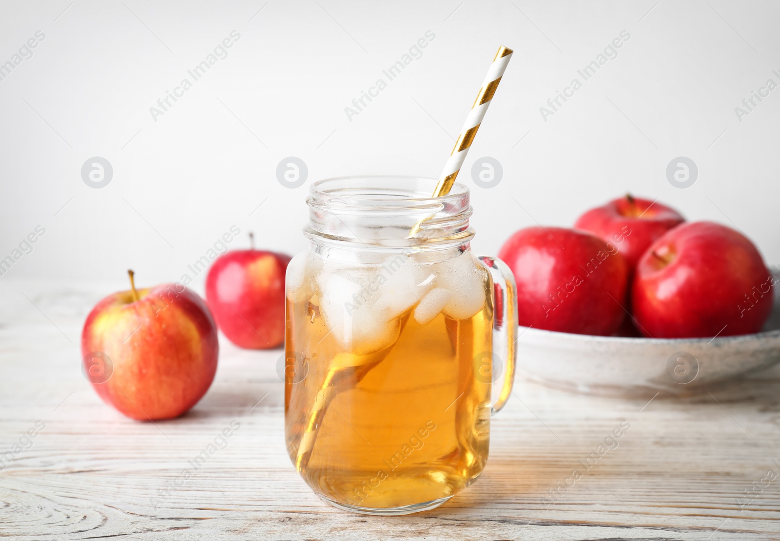 Photo of Mason jar with fresh apple juice on wooden table