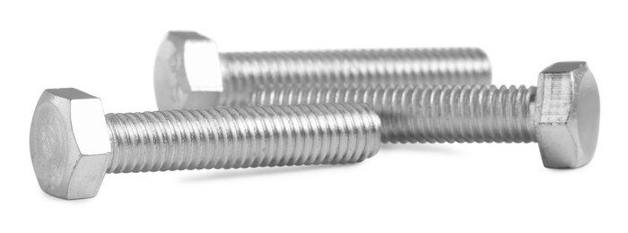 Photo of Many metal hex bolts on white background