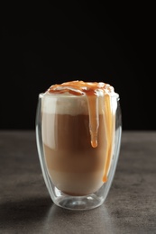 Photo of Glass with delicious caramel frappe on table