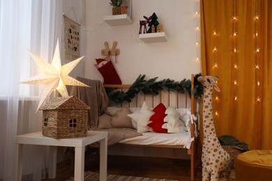 Photo of Cozy children's room with bed, toys and Christmas decor. Interior design