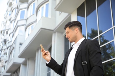 Photo of Handsome man with smartphone on city street