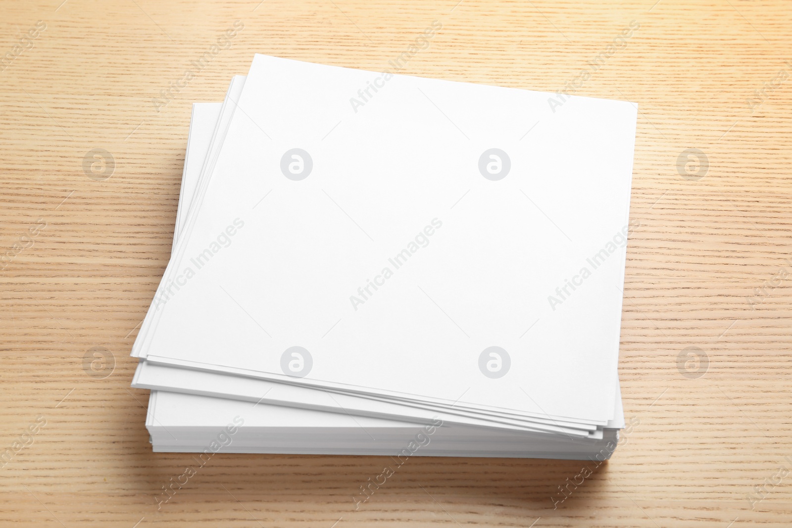 Photo of Stack of blank paper sheets for brochure on wooden background. Mock up