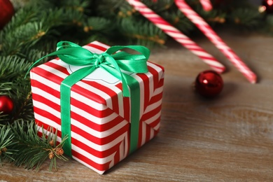 Photo of Christmas gift box on wooden table, closeup