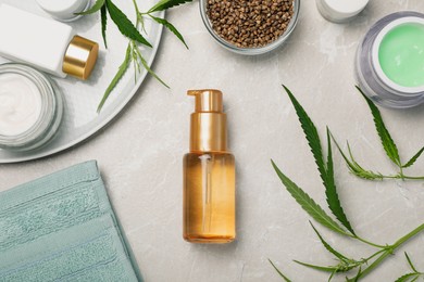 Photo of Hemp cosmetics and green leaves on light table, flat lay