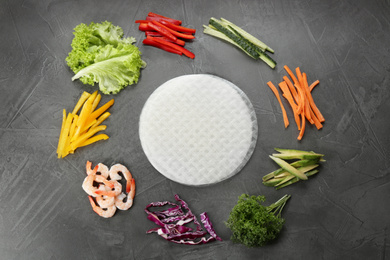 Photo of Dry rice paper and ingredients on grey table, flat lay