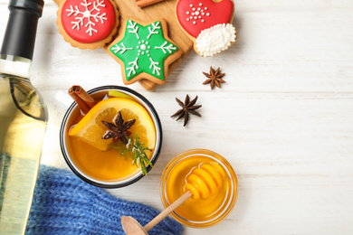 Photo of Aromatic white mulled wine served on wooden table, flat lay