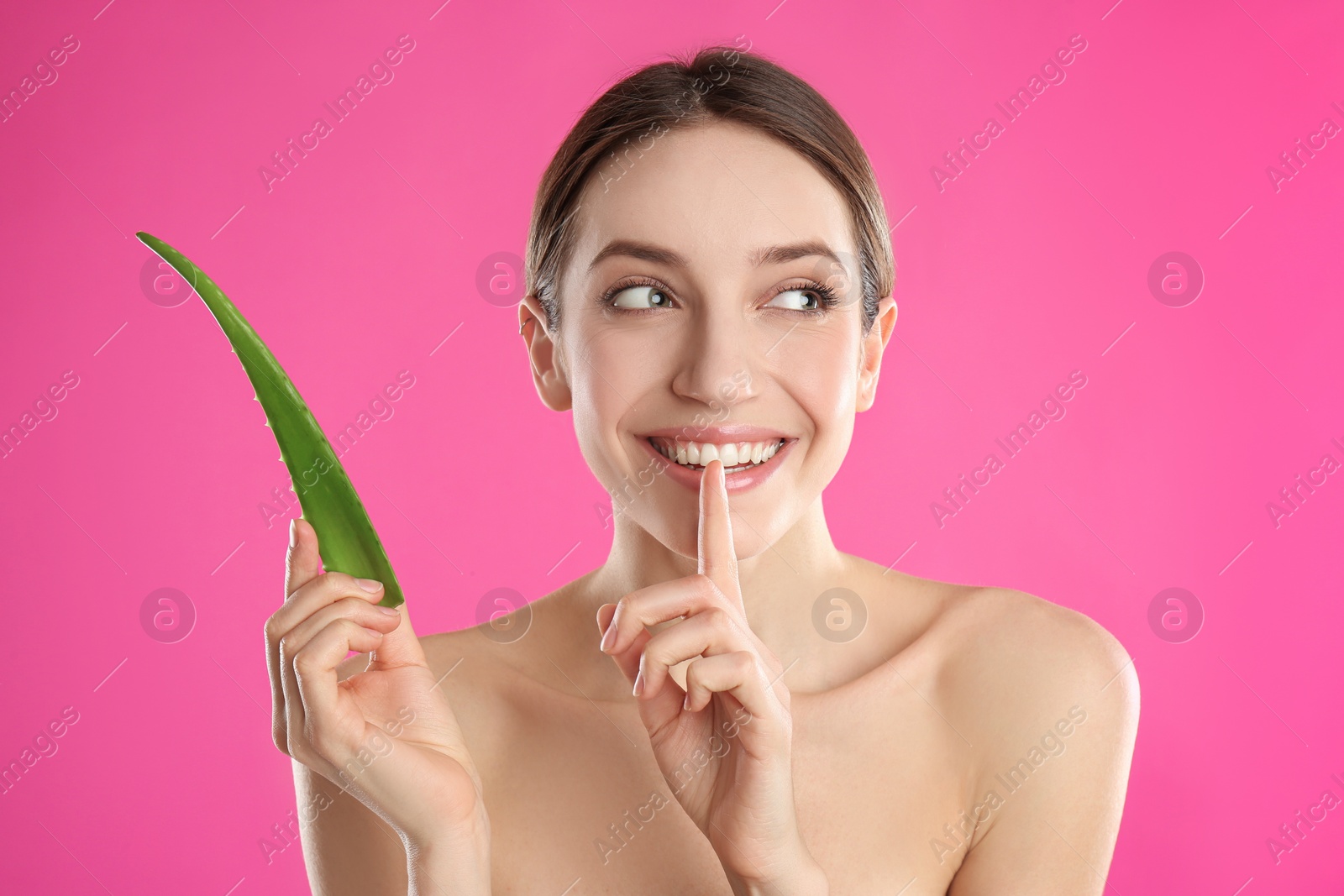 Photo of Happy young woman with aloe leaf on pink background