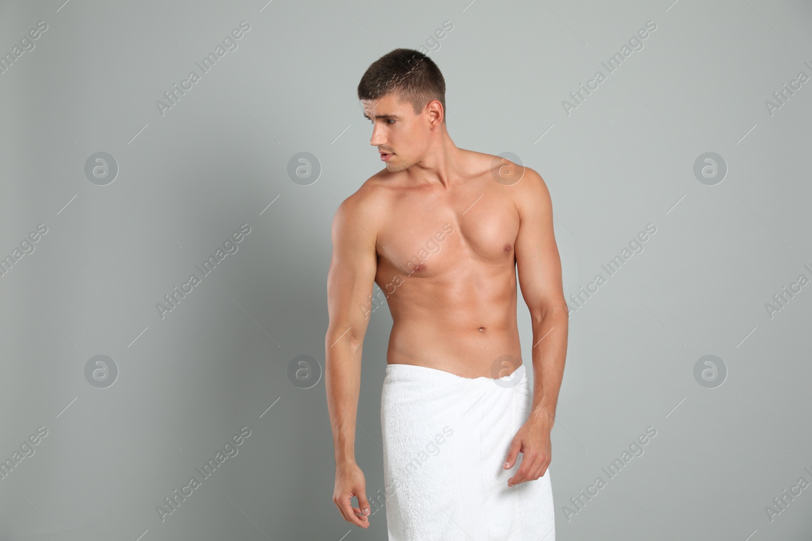 Photo of Young man with slim body on grey background