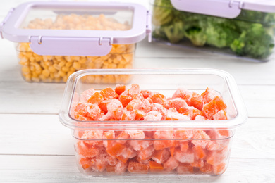 Photo of Different frozen vegetables on white wooden table