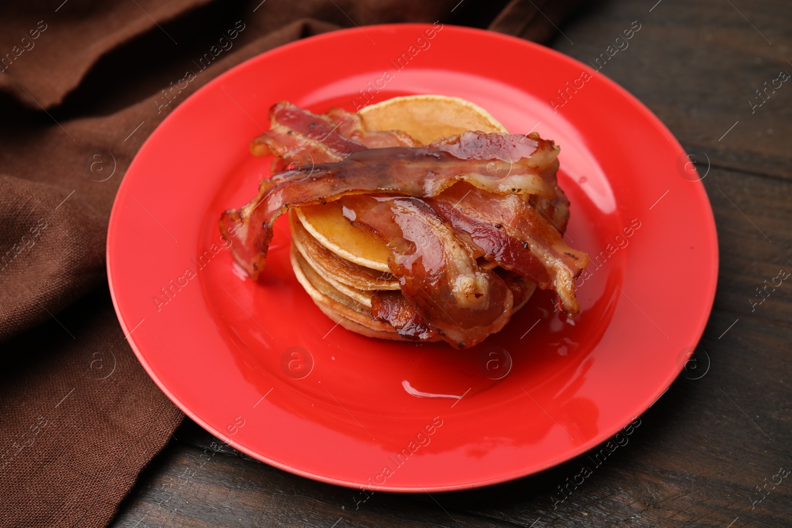 Photo of Delicious pancakes with bacon and honey on wooden table, closeup