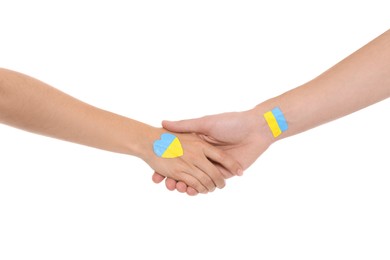 Photo of Man and woman with painted Ukrainian flags on their hands against white background, closeup