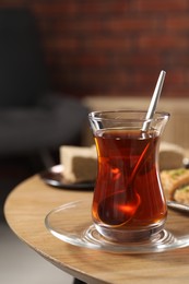 Photo of Traditional Turkish tea in glass on wooden table