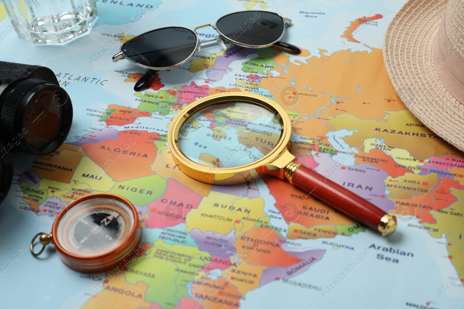 Photo of Different travel accessories on world map, closeup. Planning summer vacation trip