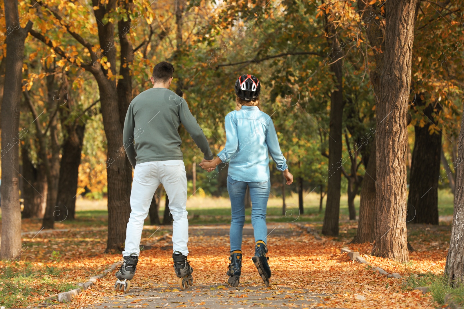 Photo of Young couple roller skating in autumn park