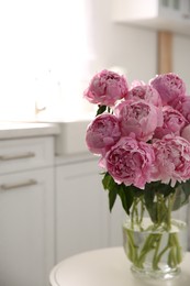 Photo of Vase with bouquet of beautiful pink peonies in kitchen