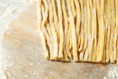 Photo of Raw homemade pasta and flour on table, closeup. Space for text