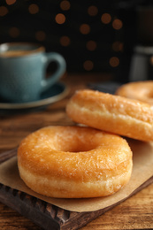 Photo of Sweet delicious glazed donuts on wooden table