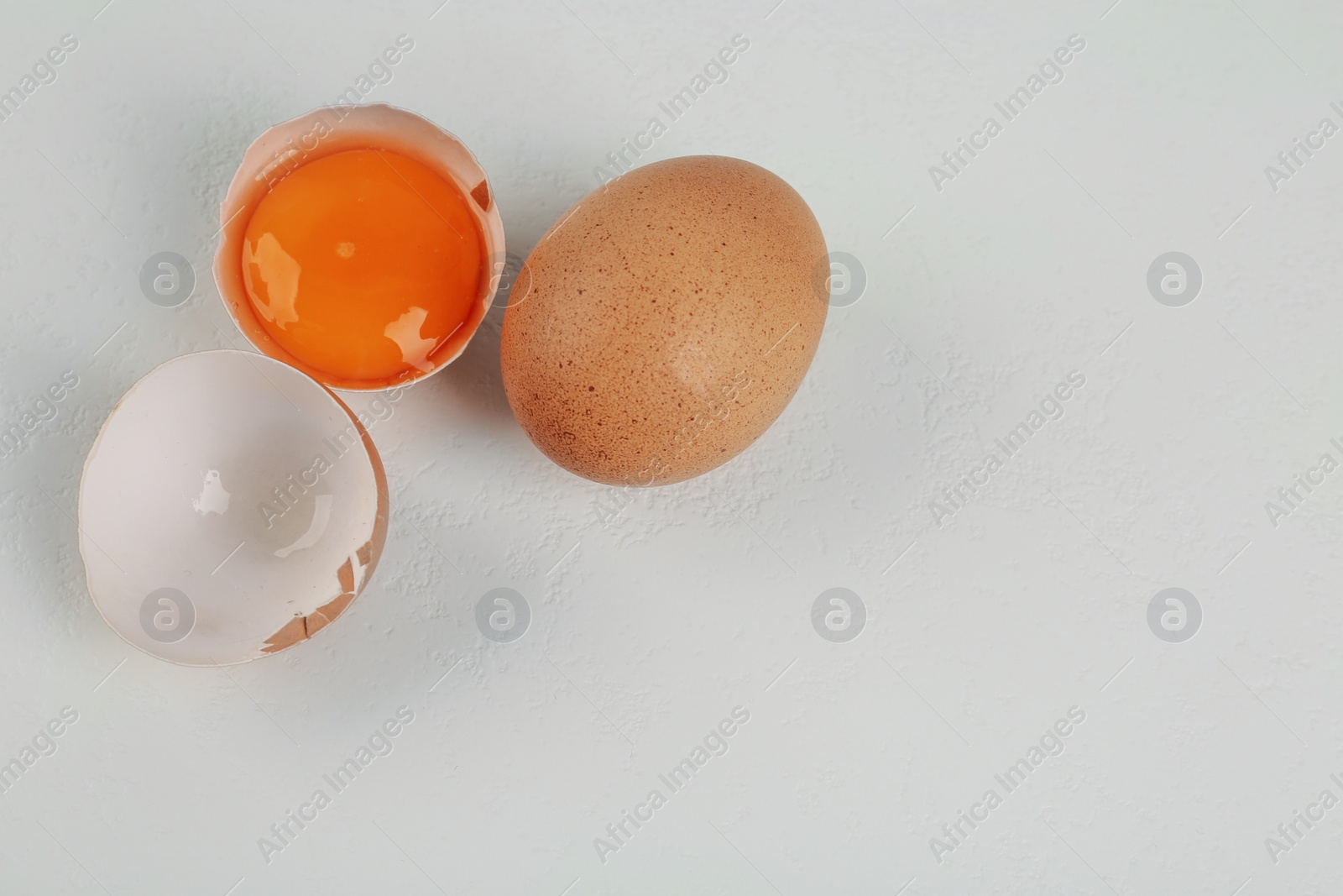 Photo of Raw chicken eggs on white table, flat lay. Space for text