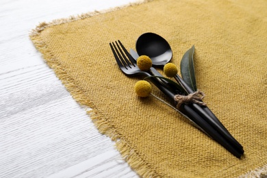 Autumn place setting with cutlery on white table, closeup