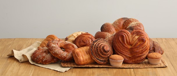 Different tasty freshly baked pastries on wooden table