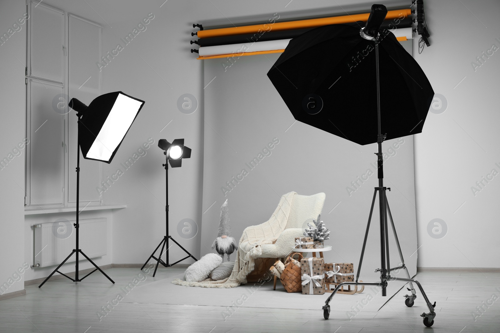 Photo of Stylish photo zone with armchair and Christmas decor in professional studio