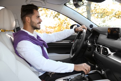 Photo of Young man in driver's seat of modern car