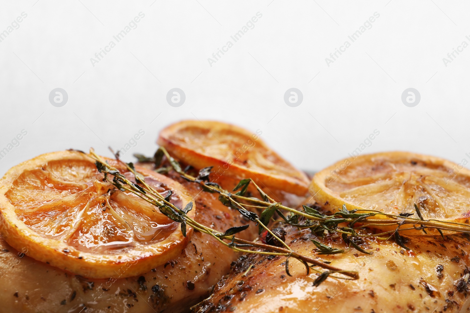 Photo of Delicious lemon chicken with herbs on white background, closeup view