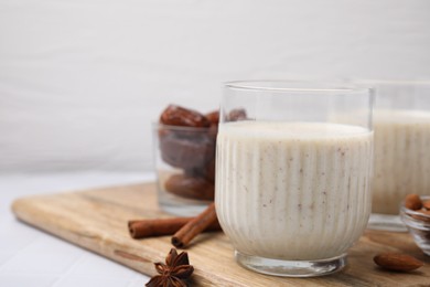 Glass of delicious date smoothie on white table, closeup. Space for text