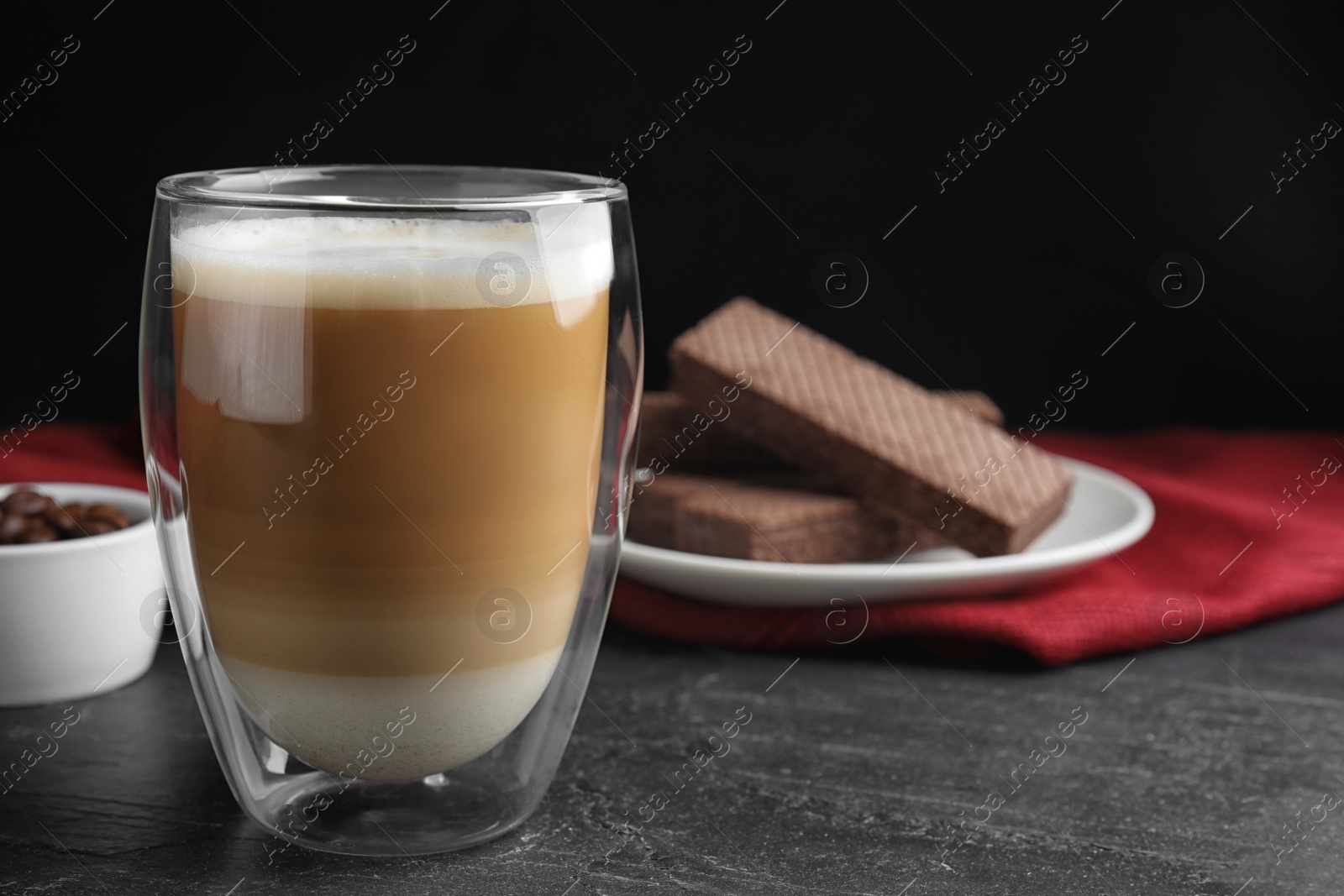 Photo of Delicious coffee and wafers on black table. Space for text