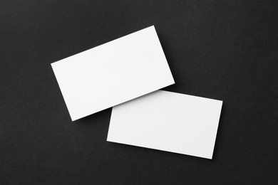 Photo of Blank business cards on black background, flat lay. Mockup for design