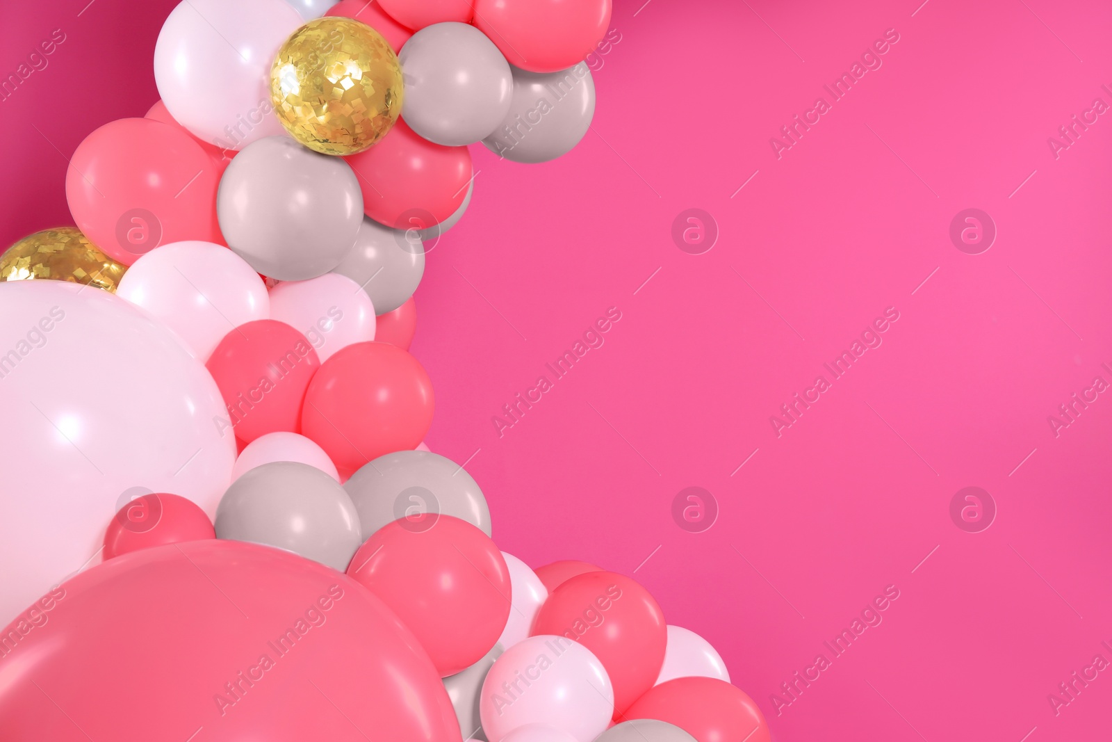 Image of Balloon garland on pink background. Festive decor