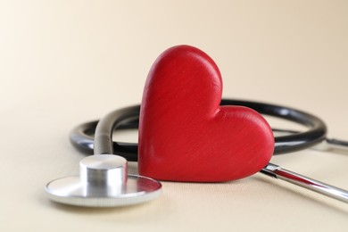 Photo of Stethoscope and red heart on beige background