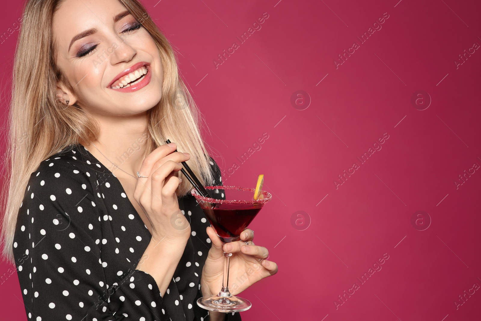 Photo of Beautiful young woman with glass of martini cocktail on color background, space for text