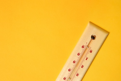Photo of Weather thermometer on yellow background, top view. Space for text