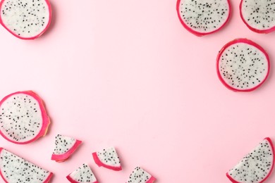 Photo of Frame of delicious cut dragon fruit (pitahaya) on pink background, flat lay. Space for text