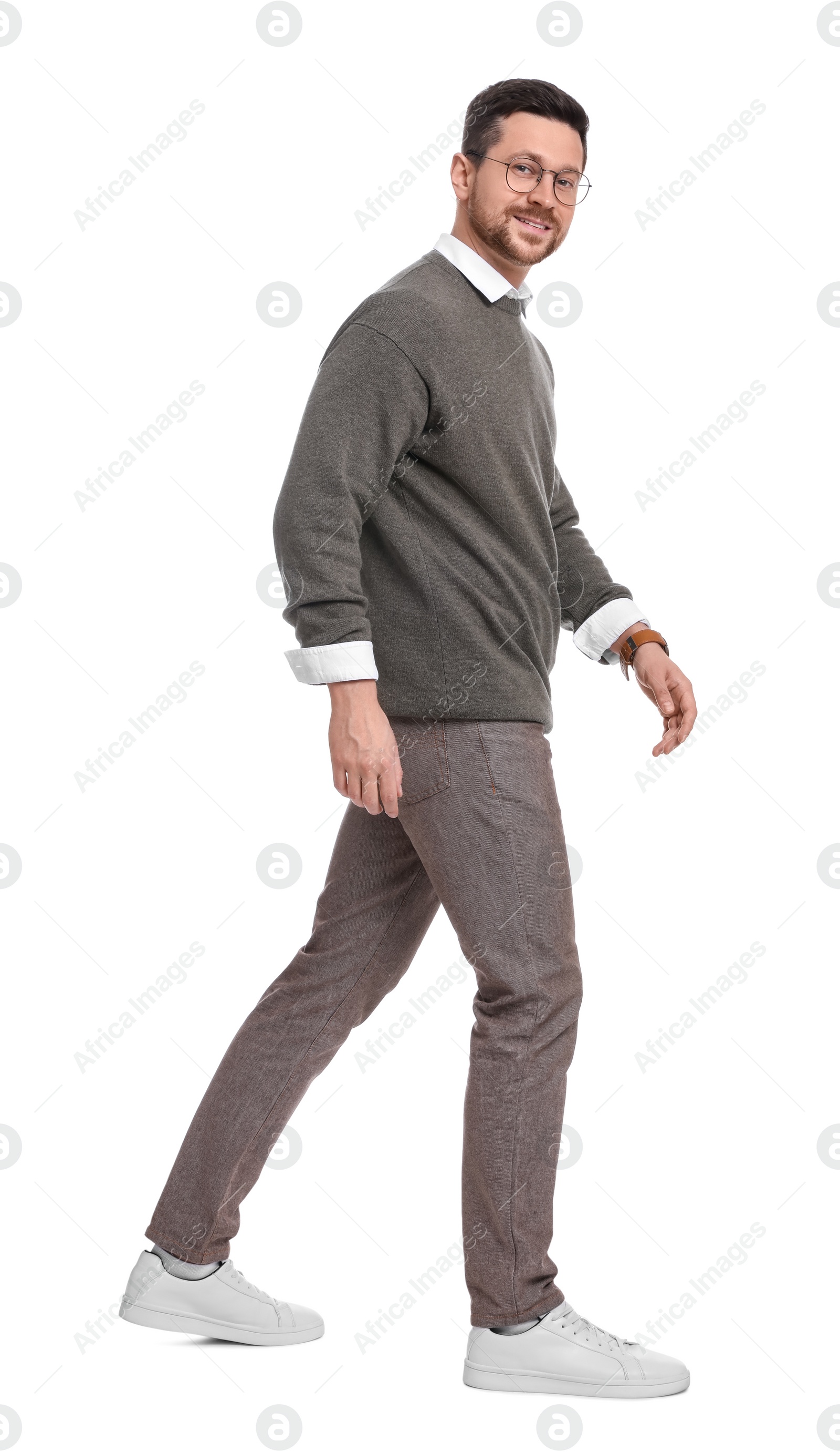 Photo of Handsome bearded businessman in eyeglasses walking on white background