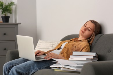 Photo of Young tired woman sleeping near books on couch indoors