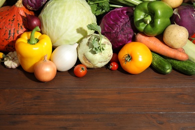 Photo of Many fresh ripe vegetables and space for text on wooden background. Organic food