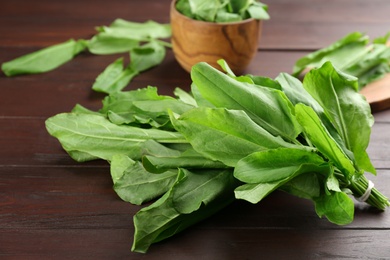 Fresh green sorrel leaves on brown wooden table, closeup