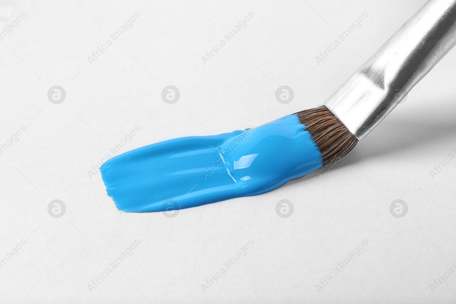 Photo of Brush with color paint and stroke on white background