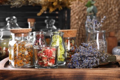 Many different herbs and dry lavender flowers on wooden board