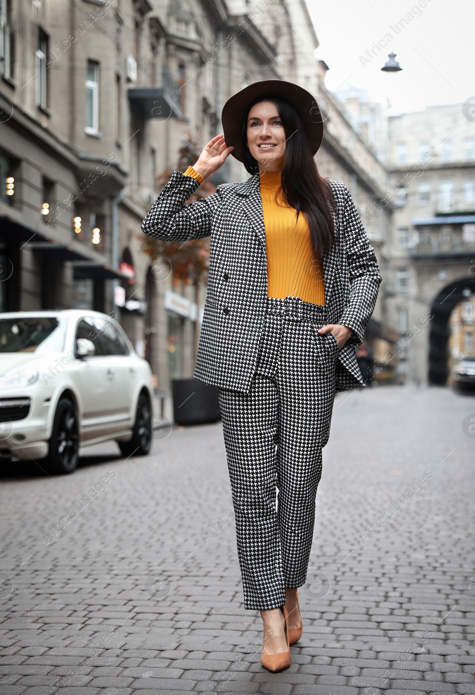 Photo of Full length portrait of beautiful woman in stylish suit on city street