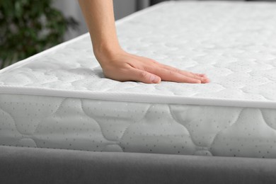 Photo of Man touching soft mattress indoors, closeup view